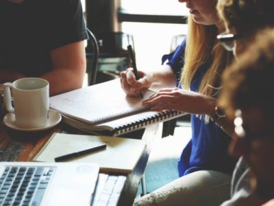 Varios jóvenes trabajando alrededor de una mesa de trabajo